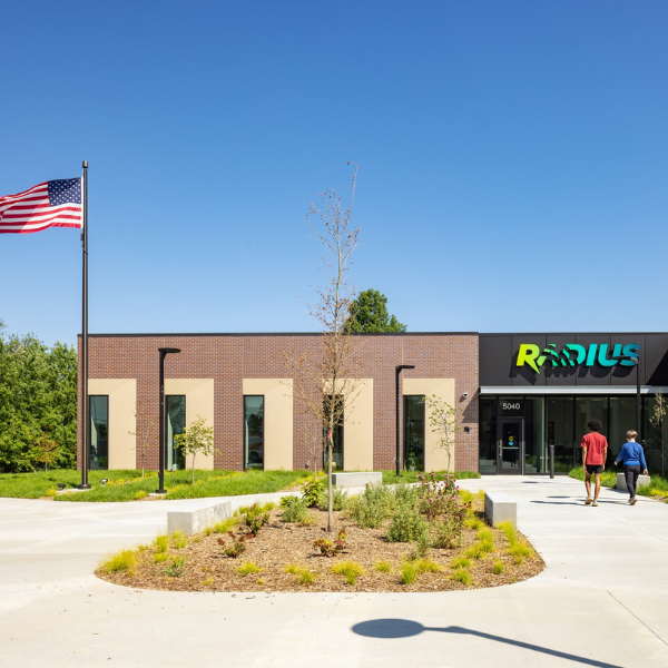 Photo of the RADIUS building with American flag waving in the wind on a sunny day.