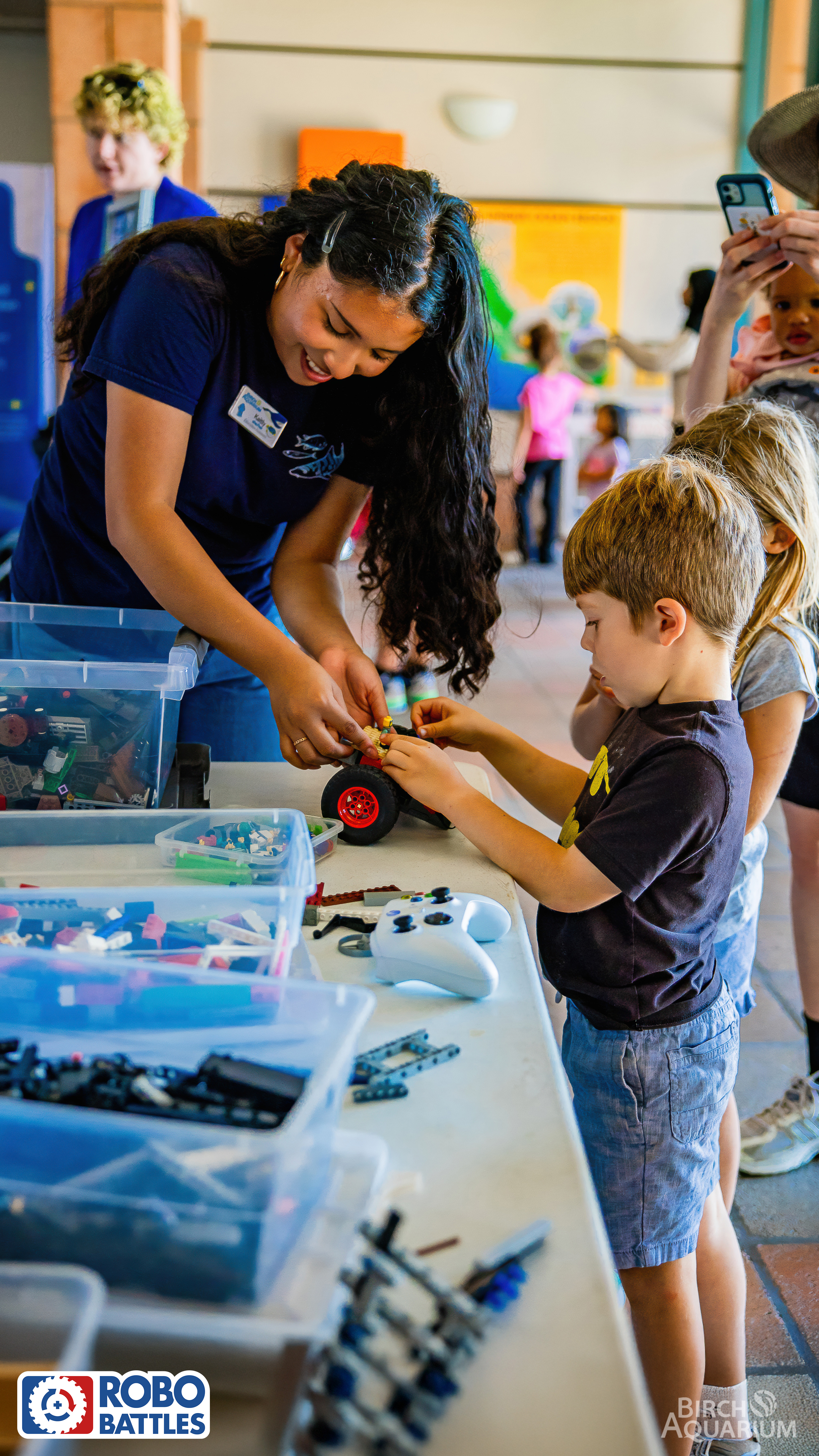 Adult assisting children with building LEGO battle bots