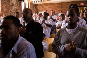 Inmates applauded Janet Connors after she told the story of her son’s murder at the Restorative Justice Retreat at the state prison in Norfolk, Mass. (Photo by Charlie Mahoney for The New York Times.)