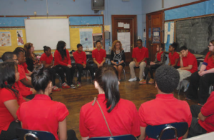 Students at Warren G. Harding Middle School in Philadelphia use a “talking piece” to indicate whose turn it is to speak during a restorative circle facilitated by teacher Denise James. (Photo by Danielle Marie Phil.)