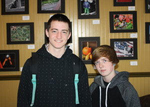 Students Richie Hall and Beth Yohe pose in front of artwork produced and exhibited by them and other Buxmont Academy classmates.