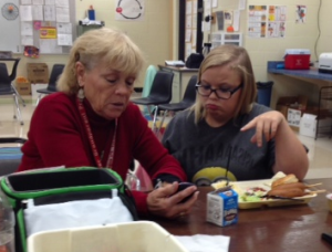 Student Odessa Reid helps Grandma – Suzanne Ham, CLC's 'foster grandparent' – learn to program her new phone over lunch.
